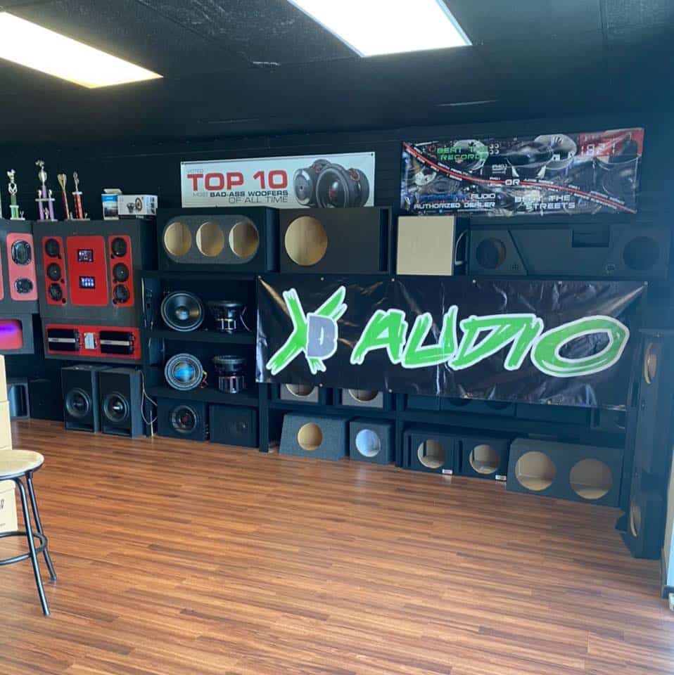 A large XD Audio sign in front of full wall speaker display at XD Audio in Central Florida