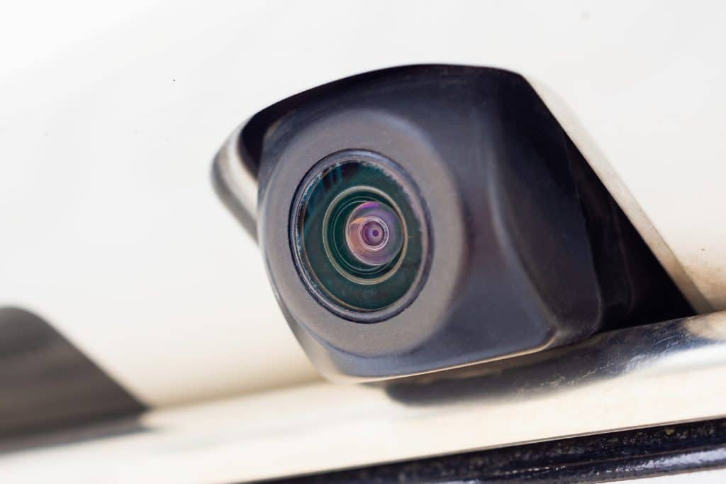 A small backup camera discreetly mounted on the outside of a vehicle.